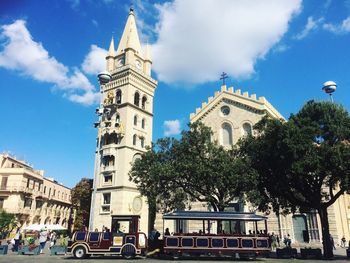 Low angle view of clock tower against cloudy sky