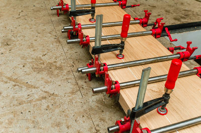 Joiner's clamps on length of bar. wooden board. close-up