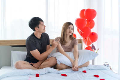 Young couple kissing on bed at home