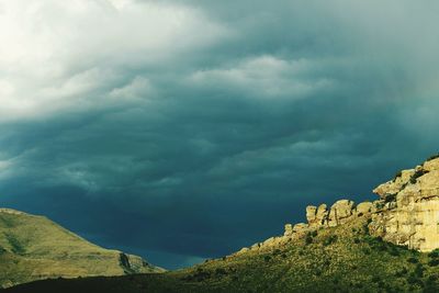 Low angle view of mountain against cloudy sky