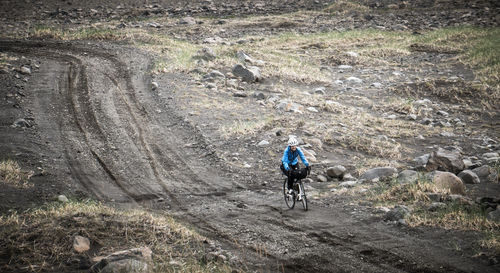 High angle view of person cycling on dirt road