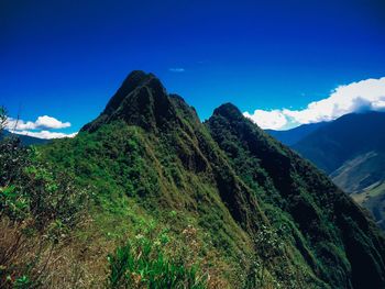 Scenic view of mountains against blue sky