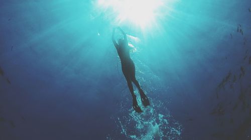 Low angle view of woman scuba diving in sea