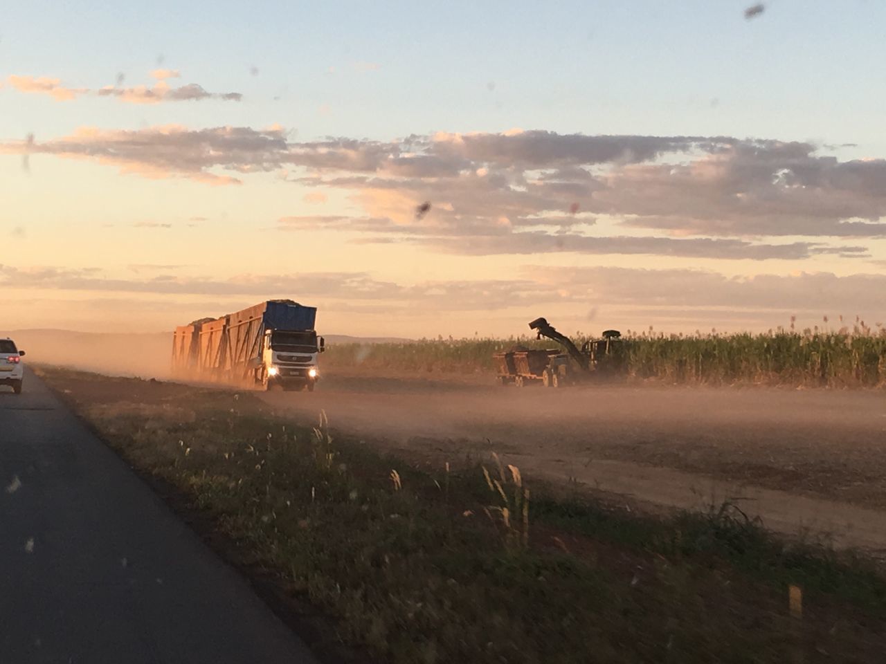 sunset, transportation, mode of transport, sky, land vehicle, nature, road, cloud - sky, outdoors, landscape, scenics, real people, men, grass, day, beauty in nature, one person, people