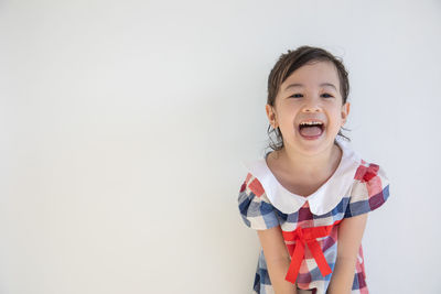 Portrait of smiling girl against white background