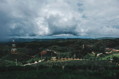 Scenic view of field and houses against sky