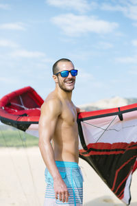 Young man standing on boat against sky