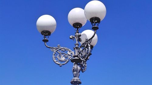 Low angle view of street light against clear blue sky on sunny day