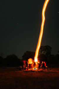 Bonfire on field against sky at night