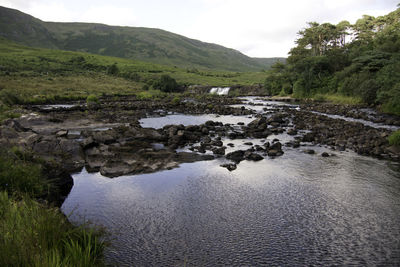 Scenic view of river amidst mountains against sky