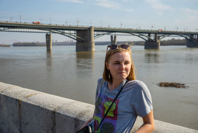 Woman on bridge over river against sky