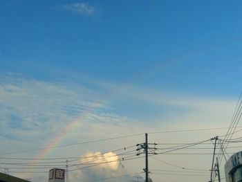 Low angle view of electricity pylon against blue sky