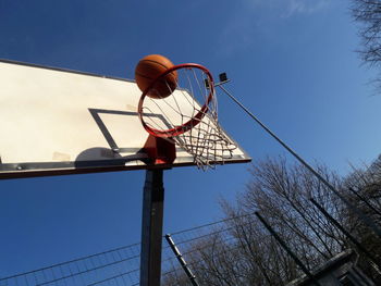 Low angle view of basketball hoop against blue sky