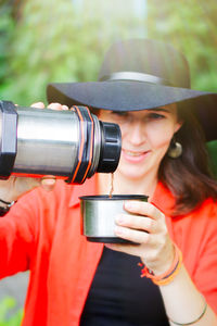 Girl pours tea from a thermos on a walk. active recreation in the form of a walk through the forest 