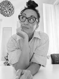 Mature woman looking away while sitting at home