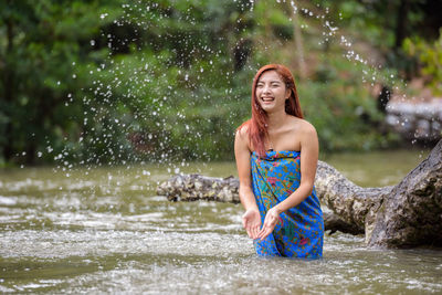 Portrait of smiling woman standing in water