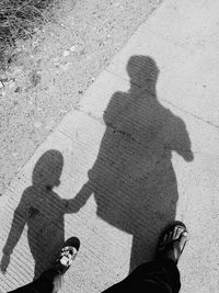 Shadow of man and woman on sand