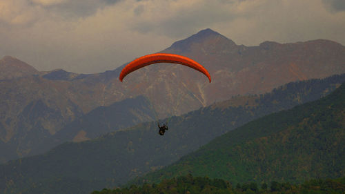 Person paragliding over mountains