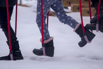 Low section of people playing at playground during winter