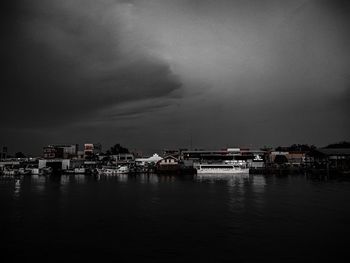 Boats moored in harbor at city against sky