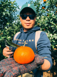 Portrait of smiling young woman holding pumpkin