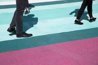 Low section of men walking on road