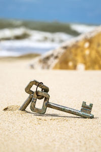 Close-up of ring on beach against sky