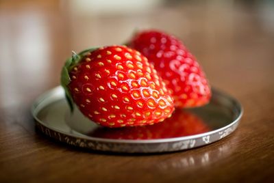 Two strawberries on jar lid