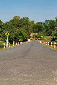 Road amidst trees against clear sky