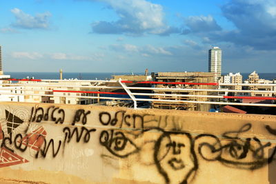 Graffiti on building in city against sky