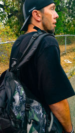 Side view of young man wearing hat