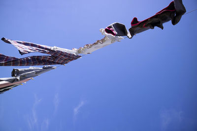 Low angle view of amusement park ride against blue sky