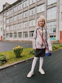 Portrait of young woman walking on road