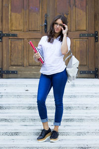 Full length of young woman using mobile phone