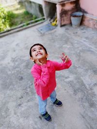 High angle view of smiling boy standing on floor