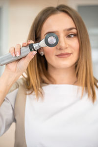 Midsection of woman holding thermometer