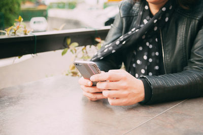 Midsection of woman using mobile phone