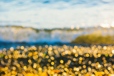 Defocused image of illuminated sea against sky