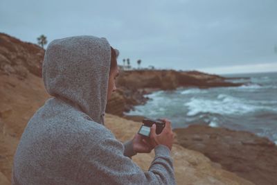 Man holding camera at beach