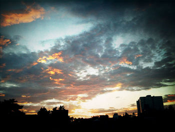 Low angle view of silhouette built structure against dramatic sky