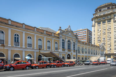 Cars on street in city against clear sky