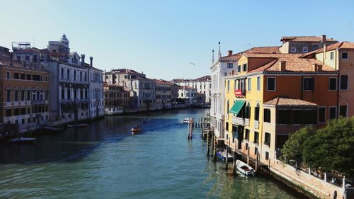 Canal amidst buildings in city against sky