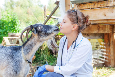 Veterinarian with goat outdoors