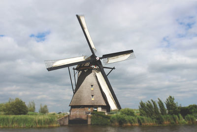 Traditional windmill on field against sky