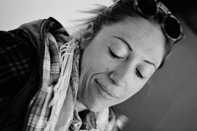 Close-up portrait of smiling young woman with eyes closed