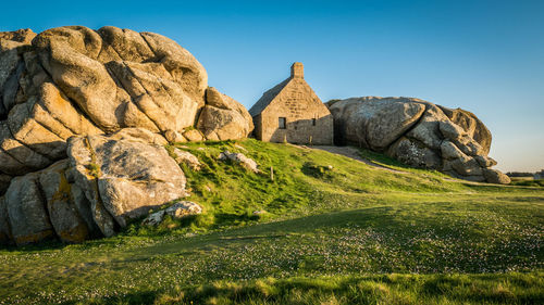 Rock formations on landscape against clear sky