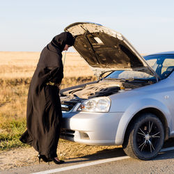 Brunette muslim woman in the reflection of the car mirror in the salon.