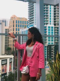 Woman standing against buildings in city