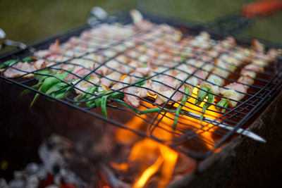 Grilled fresh onion covered by bacon in open fire. selective soft focus.