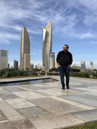 Full length of man standing by buildings against sky
